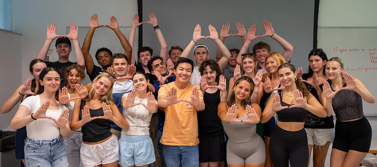 University of Miami students holding their hands up in the U shape in a group photo
