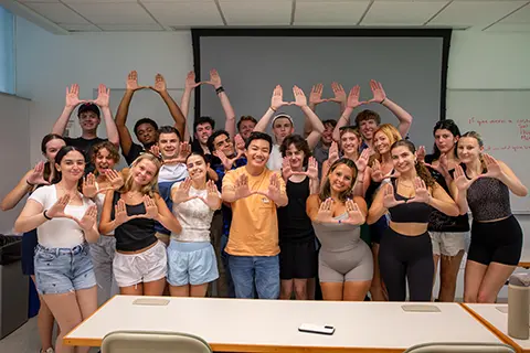 University of Miami students holding their hands up in the U shape in a group photo